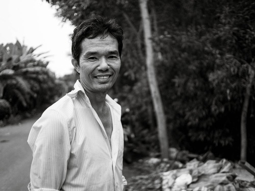 Daniel smiling on a tree-lined path
